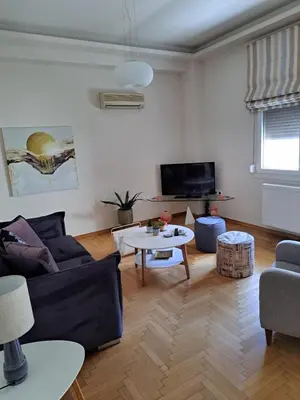 a living room with a couch and a table at Athenian Center Athens Kolonaki in Athens