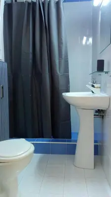 a bathroom with a black shower curtain and a sink at Theo's loft in Athens