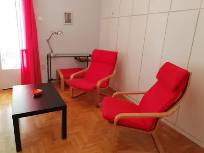 two red chairs and a table in a room at Wonderful Apartment in central Athens in Athens