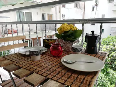 a table with plates and utensils on a balcony at Wonderful Apartment in central Athens in Athens