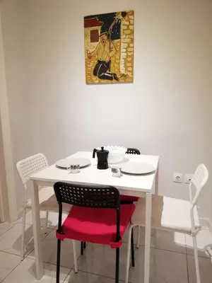 a white table and chairs with a picture on the wall at Wonderful Apartment in central Athens in Athens