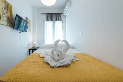 a bed with two towels in the shape of swans at Apartment in Glyfada Center in Athens