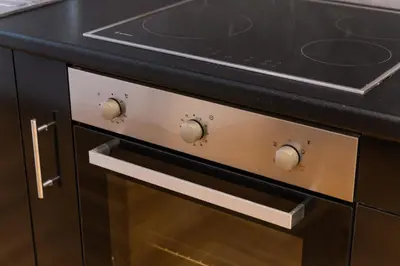a stove top oven with a black counter top at Apartment in Glyfada Center in Athens