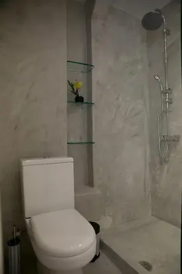a white bathroom with a toilet and a shower at Apartment in Glyfada Center in Athens