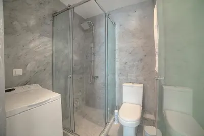 a bathroom with a toilet and a glass shower at Apartment in Glyfada Center in Athens