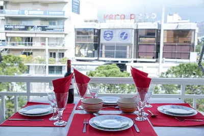 a table with red napkins and plates and glasses on it at Apartment in Glyfada Center in Athens