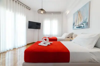 a bedroom with two beds with a red and white blanket at Apartment in Glyfada Center in Athens