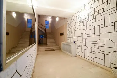 a hallway with stairs and a wall of white tiles at A Diamond of 140 m2 in Platonas Ancient Athens in Athens