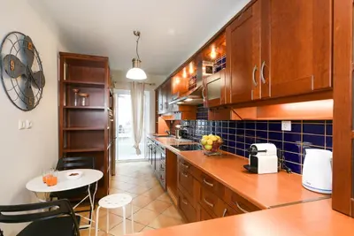 a kitchen with wooden cabinets and a table and chairs at A Diamond of 140 m2 in Platonas Ancient Athens in Athens