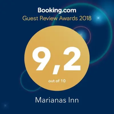 a sign that reads guest review awards with a yellow circle at Marianas Inn in Athens
