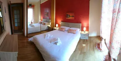 a bedroom with a large white bed and a mirror at Marianas Inn in Athens