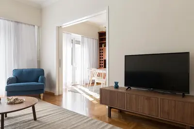 a living room with a large flat screen tv at Chic Flat in the Heart of Athens by UPSTREET in Athens
