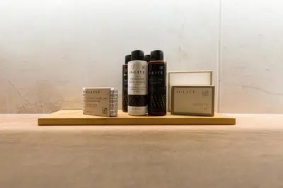a wooden shelf with three bottles oficating products on it at Chic Flat in the Heart of Athens by UPSTREET in Athens