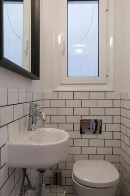 a white bathroom with a sink and a toilet at Chic Flat in the Heart of Athens by UPSTREET in Athens