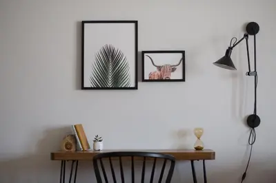 a desk with a chair and two pictures on a wall at Stylish and Spacious 2BD - Thiseio by UPSTREET in Athens