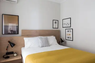 a bedroom with a bed with a yellow blanket at Stylish and Spacious 2BD - Thiseio by UPSTREET in Athens