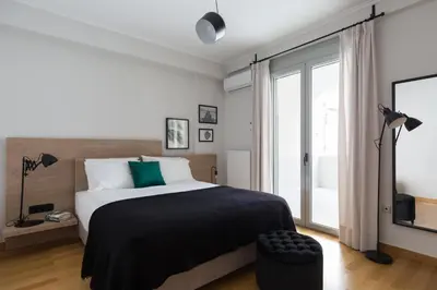 a bedroom with a bed and a large window at Stylish and Spacious 2BD - Thiseio by UPSTREET in Athens