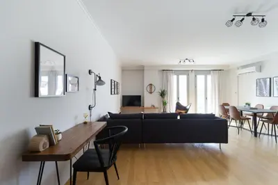 a living room with a black couch and a table at Stylish and Spacious 2BD - Thiseio by UPSTREET in Athens