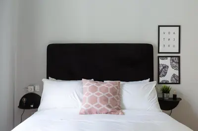 a pink pillow sitting on top of a white bed at Acropolis Core Bright & Modern Apartment by UPSTREET in Athens