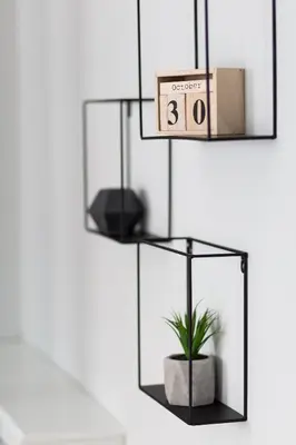 a black shelf with a potted plant on it at Acropolis Core Bright & Modern Apartment by UPSTREET in Athens