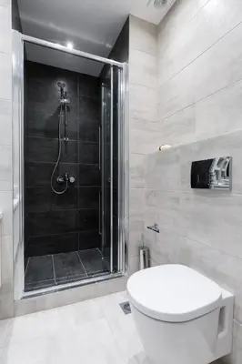 a bathroom with a shower with a toilet and a sink at Acropolis Core Bright & Modern Apartment by UPSTREET in Athens