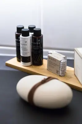 a wooden shelf with four bottles of hair products at Acropolis Heart 1BD Apartment in Plaka by UPSTREET in Athens