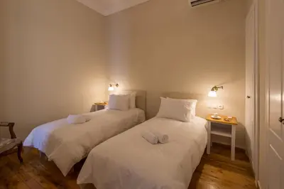 two beds with white sheets in a room at Artdecoathens in Athens