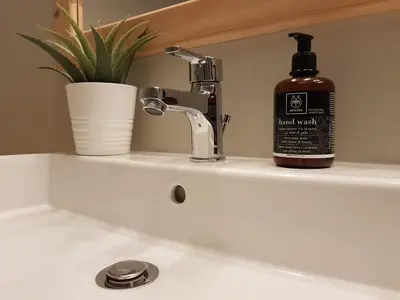 a bottle of soap sitting on a bathroom sink at Artdecoathens in Athens