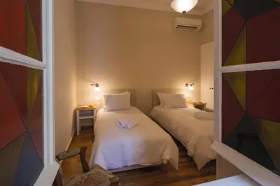 two beds in a small room with a window at Artdecoathens in Athens