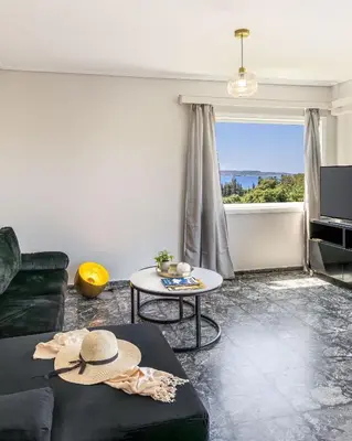 a living room with a black couch and a table at Seaside Secret by BluPine in Athens