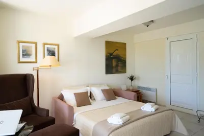 a hotel room with a bed and a chair at Apollo complex 1 in Porto Rafti
