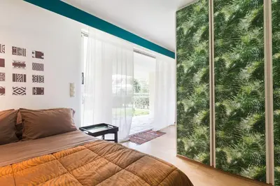 a bedroom with a large glass door with a large window at Garden Studio 55 s.m. in Athens