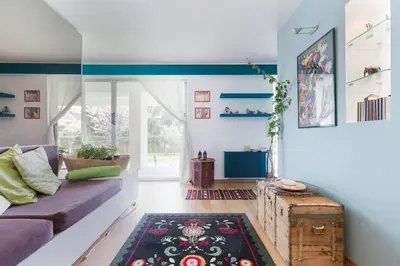 a living room with a purple couch and a rug at Garden Studio 55 s.m. in Athens