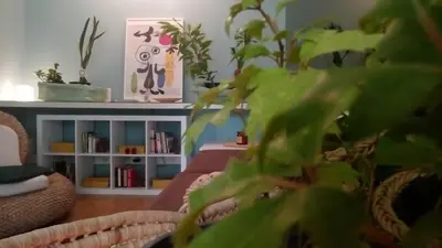 a room with a couch and a book shelf with plants at Garden Studio 55 s.m. in Athens