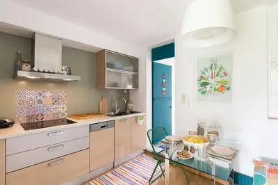 a kitchen with a glass table and a blue door at Garden Studio 55 s.m. in Athens