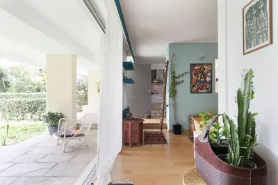 a house with a hallway with plants and a living room at Garden Studio 55 s.m. in Athens