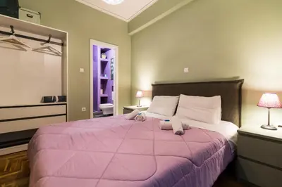 a bedroom with a large bed with a pink blanket at Modern-Vintage apartment by Acropolis museum in Athens
