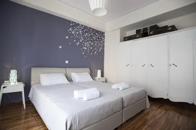a bedroom with a white bed and a blue wall at Modern-Vintage apartment by Acropolis museum in Athens