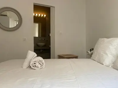 a bedroom with a white bed and a mirror at Bright and roomy apartment, in the heart of Athens in Athens