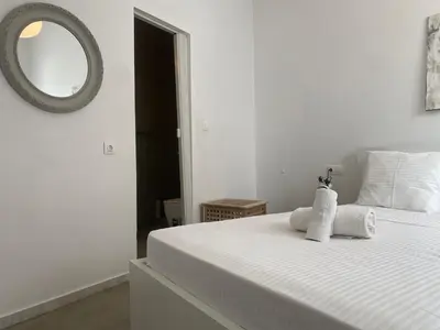 a white bedroom with a bed with towels on it at Bright and roomy apartment, in the heart of Athens in Athens