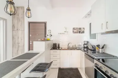 a white kitchen with white cabinets and a sink at Zeus by Heloni Apartments in Athens