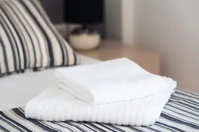 two white towels stacked on top of a bed at Zeus by Heloni Apartments in Athens