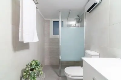 a white bathroom with a toilet and a shower at Zeus by Heloni Apartments in Athens