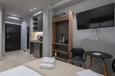 a bedroom with a bed and a television on a wall at Furla Apartments Athens in Athens
