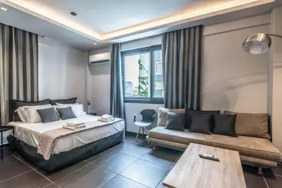 a bedroom with a bed and a couch at Furla Apartments Athens in Athens