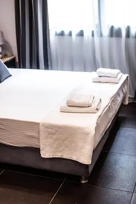 a bed with two towels sitting on top of it at Furla Apartments Athens in Athens