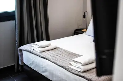 a room with a bed with white towels on it at Furla Apartments Athens in Athens