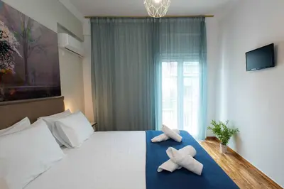a bedroom with a bed with two towels on it at Blue Ark Stylish Athens in Athens