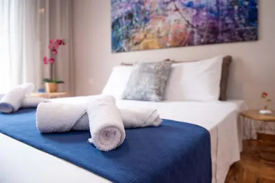 a bedroom with a bed with towels on it at Blue Ark Stylish Athens in Athens