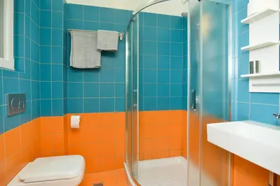 a bathroom with orange and blue tiles and a shower at Athens heart, Syntagma metro studio in Athens